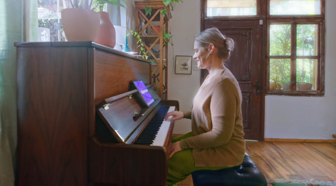 A selection of the best piano books for beginners displayed alongside a tablet running Simply Piano.